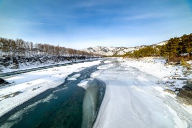 Karla kaplı dağlar ve dağ nehri manzarası