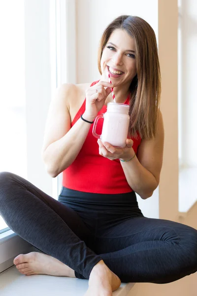 Happy fit young woman with smoothie — Stock Photo, Image