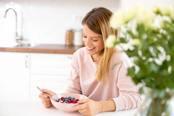 Young woman in her home kitchen eating breakfast — Stock Photo, Image