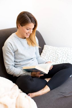 genç kadın kanepede kitap okuma