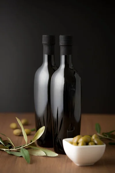 Two Olive Oil Black Bottles Wooden Table Black Background Olive — Stock Photo, Image