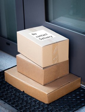 Çevrimiçi satın alınan eşyaların teslimatı için ön kapıya bırakılan paketler