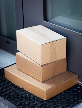 Çevrimiçi satın alınan eşyaların teslimatı için ön kapıya bırakılan paketler