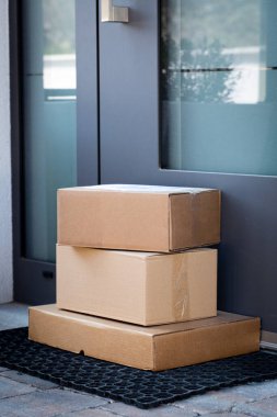 Çevrimiçi satın alınan eşyaların teslimatı için ön kapıya bırakılan paketler