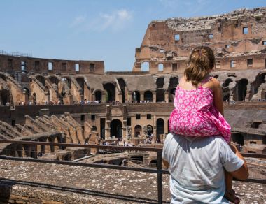 Father is holding his daughter to see the inside arena of Coliseum clipart