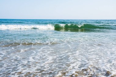 Deniz gelgit dalgaları resort bir güneşli kumlu plajda beyaz köpük ile