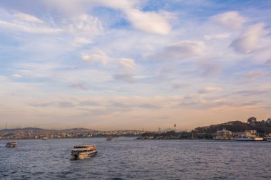Doğal görünümü ile turistik gemi İstanbul Boğazı üzerinde günbatımı gökyüzü bulutlu