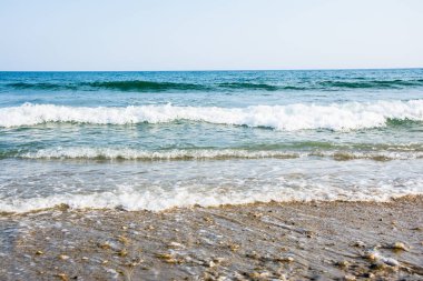 Deniz gelgit dalgaları resort bir güneşli kumlu plajda beyaz köpük ile