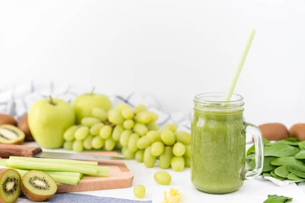 Elma, kereviz, üzüm, ıspanak ve kivi yapılmış cam yeşil smoothie