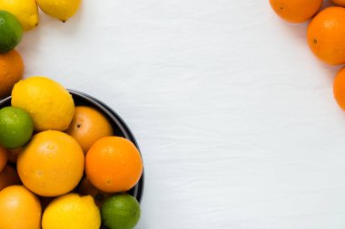 Tüm turuncu farklı türde bir kase: portakal, greyfurt, limon ve beyaz bez zemin üzerine limon kopyalama alanı