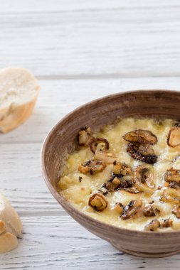 Ev yapımı peynir dip ile zengin lezzet Fransız peyniri Brittany bölgesi veya brie, karamelize soğan ve kuru otlar baget dilimleri ile servis yapılır. Beyaz ahşap zemin üzerine içten snack