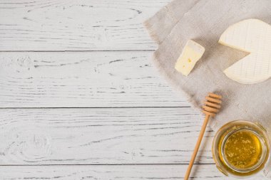 Yumuşak peynir Normandiya bölgesinin bir dilim, bal ve kopya alanı, üstten görünüm Beyaz ahşap zemin üzerine kumaş üzerine kaşık ile Fransız