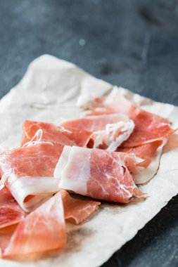İspanyolca jambon jamon serrano veya İtalyan prosciutto crudo rustik koyu arka plan üzerinde