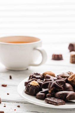 Ham el yapımı çikolata şekerleme, çay beyaz ahşap zemin üzerinde. Sağlıklı kahvaltı vegan tatlılar