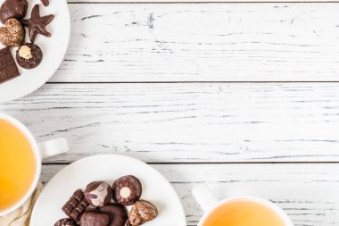 Ham el yapımı çikolata şekerleme, iki bardak çay beyaz ahşap zemin üzerinde. Sağlıklı kahvaltı vegan tatlılar. Kopya alanı ile Üstten Görünüm