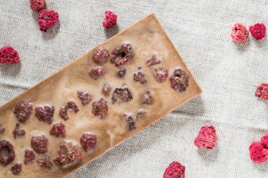 Çiğ vegan el yapımı çikolata ile kumaş arka plan üzerinde kurutulmuş frambuaz. Sağlıklı gıda vejetaryen kavramı. Üstten Görünüm