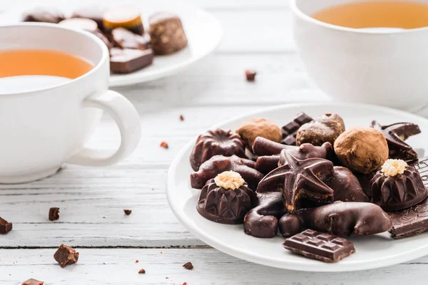 Ham el yapımı çikolata şekerleme, iki bardak çay beyaz ahşap zemin üzerinde. Vegan tatlılar ile sağlıklı snack