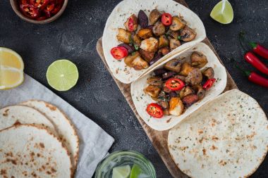 Taco ızgara mantar, İspanyol acılı sosis chorizo, Meksika ekmeği, Kıbrıs peynir Hellim, sıcak soğuk, Kuru kekik ve bardak limonlu su, rustik koyu arka plan üzerinde Üstten Görünüm
