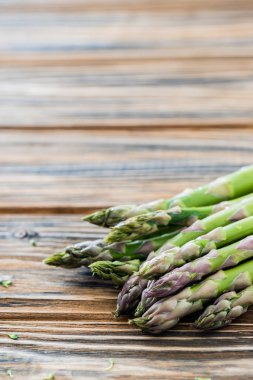 Ahşap masa üzerinde ham yeşil kuşkonmaz grup. Kopya alanı