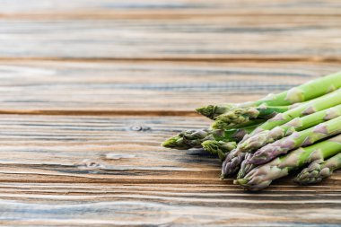 Ahşap masa üzerinde ham yeşil kuşkonmaz grup. Kopya alanı