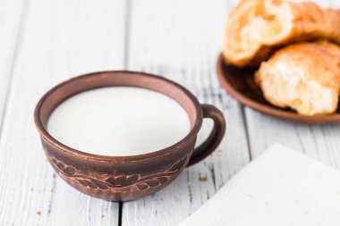 Süt ve kruvasan kahvaltı. Beyaz rustik masa