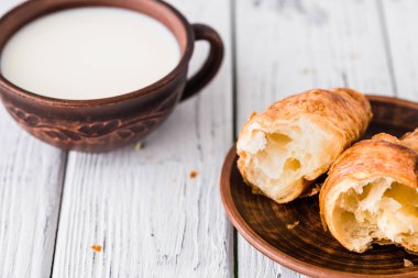 Kruvasan ve süt kahvaltı. Beyaz rustik masa