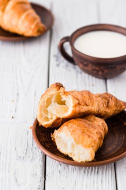 Kruvasan ve süt kahvaltı. Beyaz rustik masa