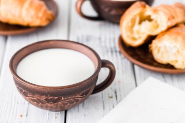 Süt ve kruvasan kahvaltı. Beyaz rustik masa