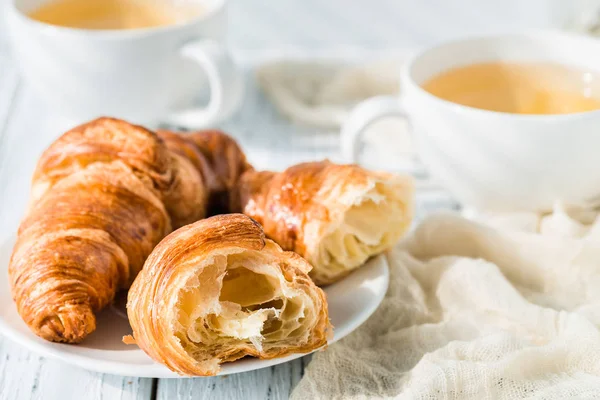 Croissants with cups of herbal tea on white rustic table — Stock Photo, Image