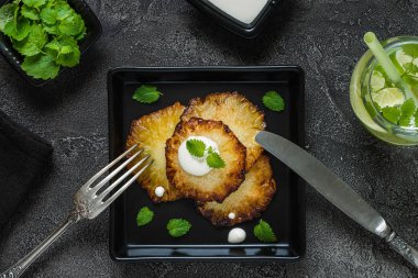 Fried ananas dilimleri Creme fraiche, koyu arka plan ile. Üstten Görünüm
