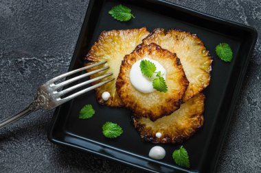 Fried ananas dilimleri Creme fraiche, koyu arka plan ile. Üstten Görünüm