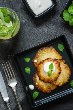 Fried ananas dilimleri Creme fraiche, koyu arka plan ile. Üstten Görünüm