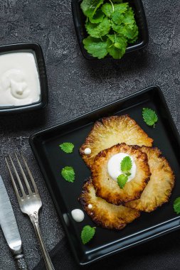 Fried ananas dilimleri Creme fraiche, koyu arka plan ile. Üstten Görünüm