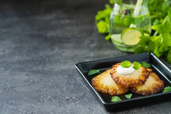 Fried ananas dilimleri Creme fraiche, koyu arka plan ile. Kopya alanı