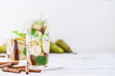 Serinletici içecek armut, beyaz masanın üzerine tarçın ile. Kopya alanı