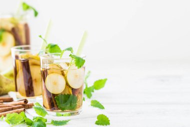 Serinletici içecek armut, beyaz masanın üzerine tarçın ile. Kopya alanı