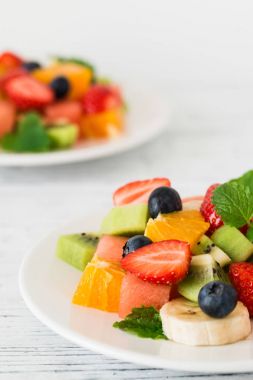 Ahşap masa üzerinde taze meyve salatası. Yakın çekim