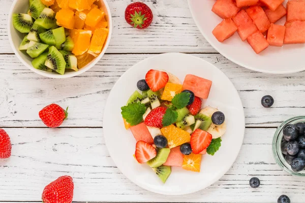 Ahşap masa üzerinde taze meyve salatası. Üstten Görünüm