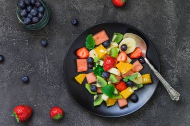 Siyah plaka üzerinde taze meyve salatası. Üstten Görünüm