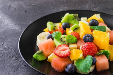 Koyu arka plan üzerine taze meyve salatası
