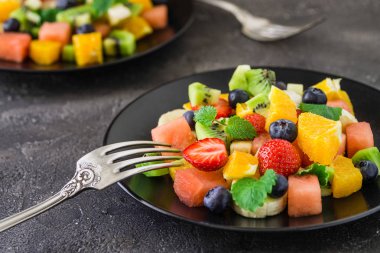 Koyu arka plan üzerine taze meyve salatası