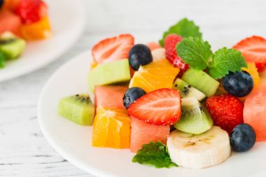 Ahşap masa üzerinde taze meyve salatası. Yakın çekim