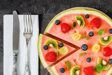 Bütün karpuz pizza dilimlenmiş meyve, koyu arka plan, üstten görünüm