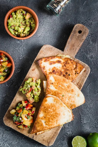 Z grilla (tortilli) quesadillas z salsą, guacamole. Ciemne tło — Zdjęcie stockowe