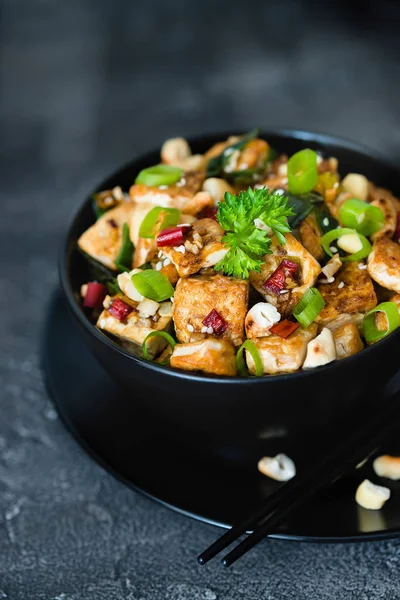 Kızarmış tofu, kaju, chili koyu arka plan üzerine ilave edin