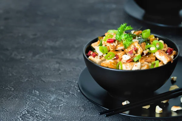 Kızarmış tofu, kaju, chili koyu arka plan üzerine ilave edin. Kopya alanı