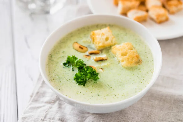 Green healthy cream soup with  broccoli, crackers, cashew, parsley — Stock Photo, Image