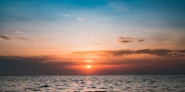 Bulutlu katmanlı günbatımı okyanus üzerinde. Sükunet için arka plan