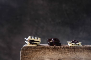 Ahşap masa, koyu arka plan üzerinde çeşitli çiğ çikolata şekerleme. 