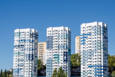 Three tall light blue modern apartment buildings. Close-up clipart